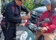 Brimob Tohpati Bagikan Bendera Merah Putih kepada Pengendara, Sambut HUT RI ke 80